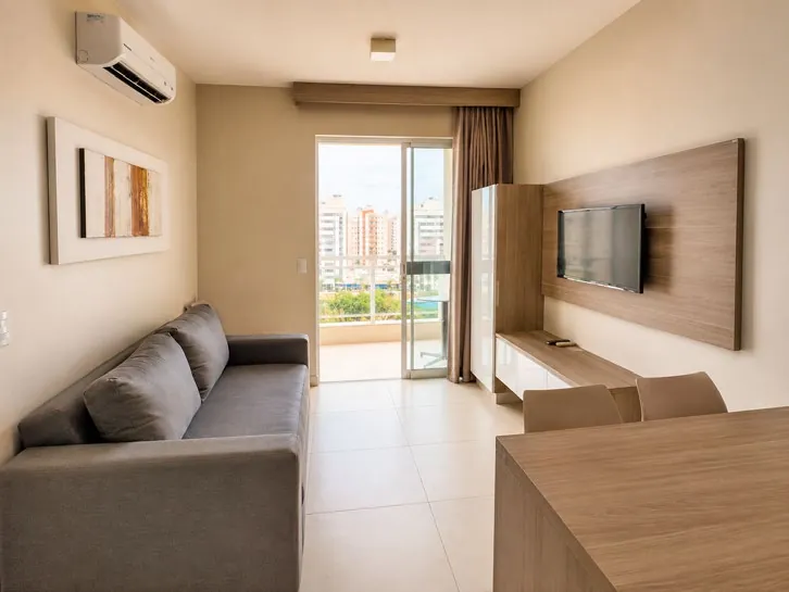 Sala com sofá, TV e varanda
